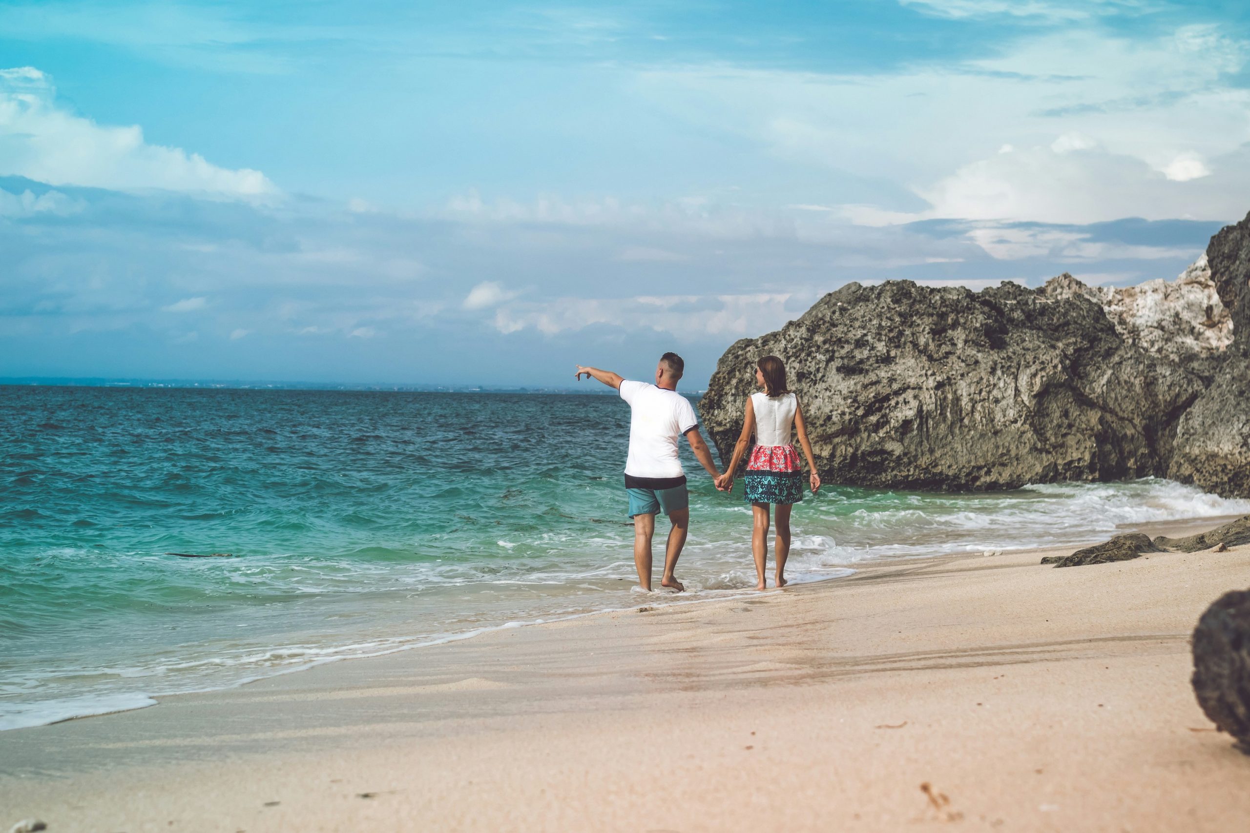 Couple walking hand in hand on a tropical beach